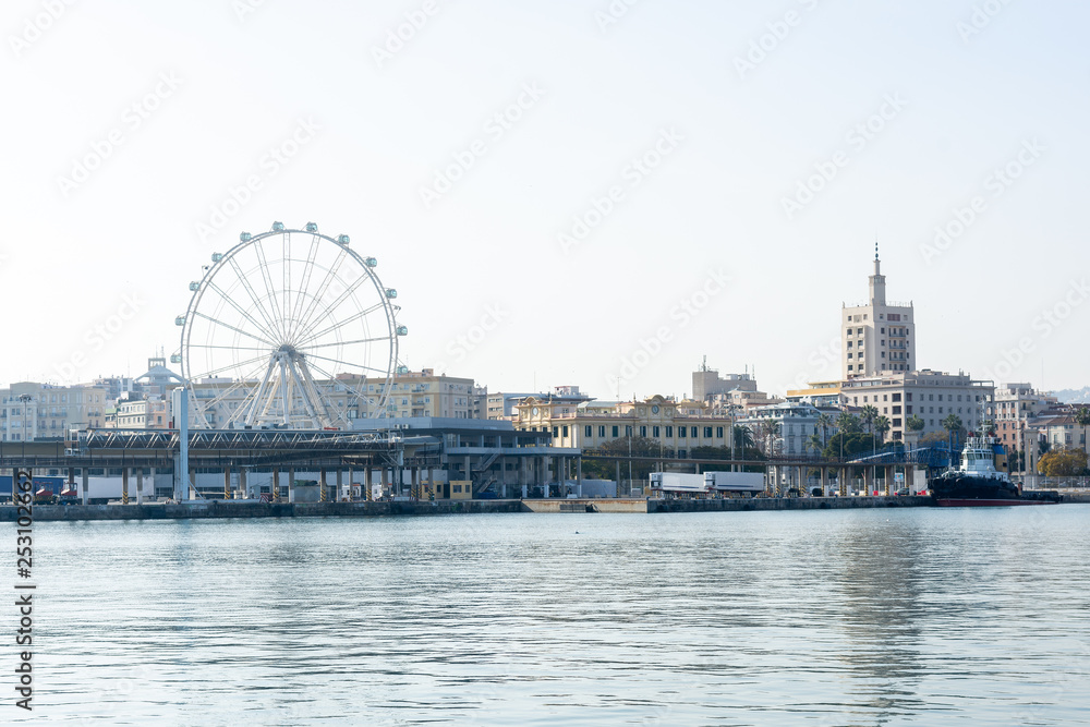 Port of Malaga with ferris wheel in background on a sunny day