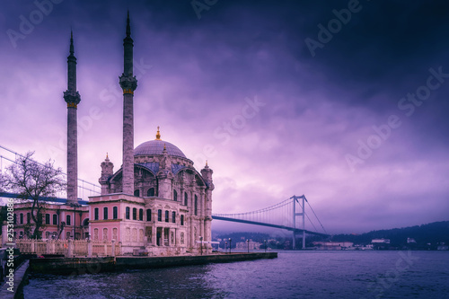 Ortakoy Mosque and Bosphorus Bridge in Istanbul, Turkey. Dramatic sky. The 15 July Martyrs Bridge in a fog
