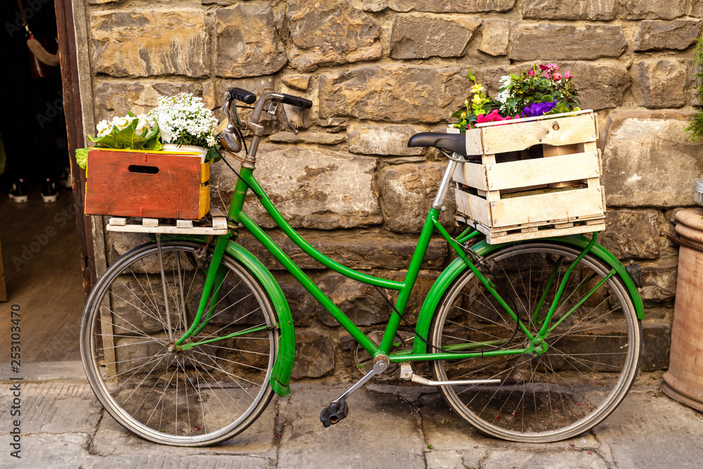 Beautiful charming street landscape with an old bike with flowers in drawers