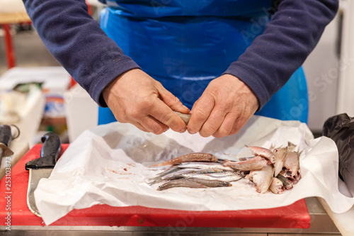 vendor cutting fish. A typical scene at the traditional fish market photo