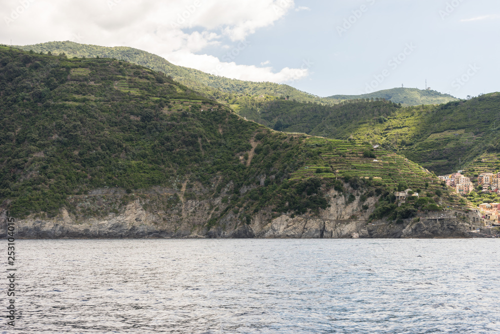 Italy, Cinque Terre, Monterosso, a body of water with a mountain in the background