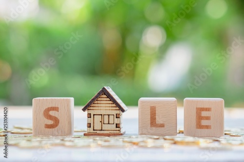 Wooden block word SALE and house model. Property investment and planning to sale house.