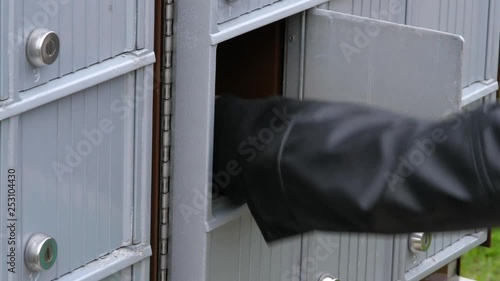 Close-up of a community mailbox as a person collects a package and letter mail