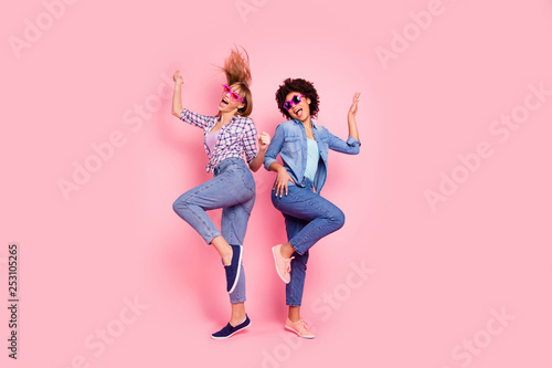 Full length body size profile side view portrait of two person nice carefree attractive playful cheery girls in casual checkered shirt having fun rejoice isolated over pink pastel background