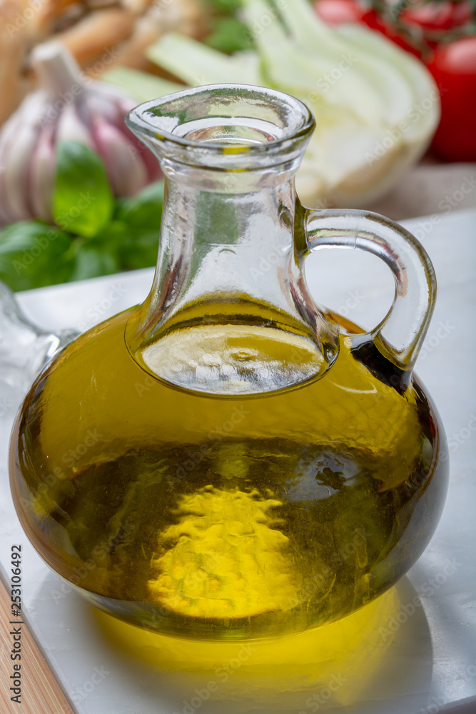 Virgin natural olive oil is glass bottle, served with traditional Mediterranean food Virgin natural olive oil is glass bottle, served with traditional Mediterranean food