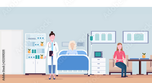 female doctor and girl visiting patient senior woman lying bed intensive therapy ward healthcare concept hospital room interior modern medical clinic horizontal