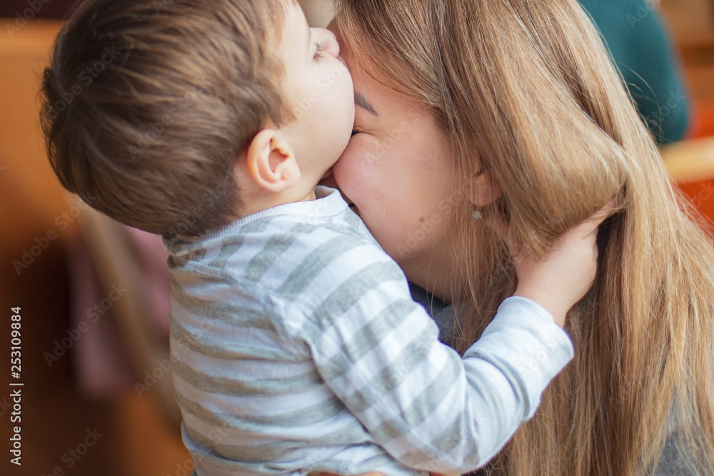 Happy mother hugs and kisses her son, a little good boy. The family rest in the cafe, they eat desserts, drink drinks, laugh and play, happy family day. selective focus, noise effect Happy mother hugs and kisses her son, a little good boy. The family rest in the cafe, they eat desserts, drink drinks, laugh and play, happy family day. selective focus, noise effect