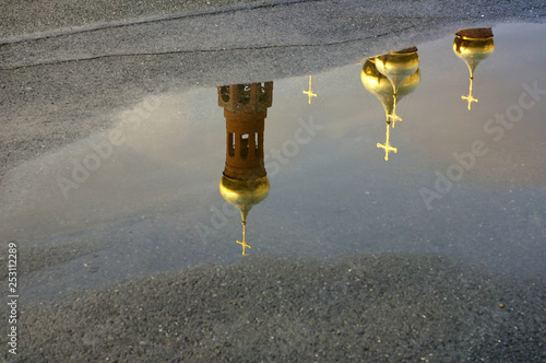 domes and crosses of the Orthodox Church reflected in puddle