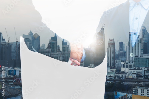 business man greeting with shaking hands partnership successful corporate dealing working together concept with double exposure of night cityscape in city metropolis landscape. photo