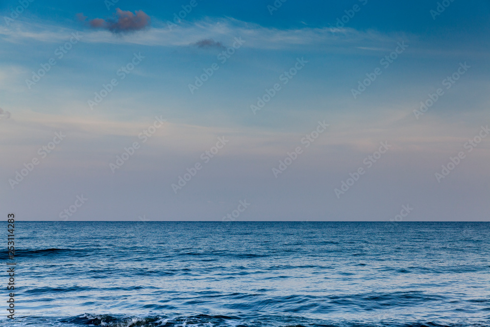 Fototapeta premium Seascape with clouds hanging over calm sea in calm weather.