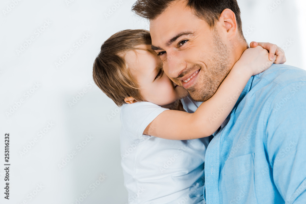 smiling father hugging adorable preschooler son at home with copy space smiling father hugging adorable preschooler son at home with copy space
