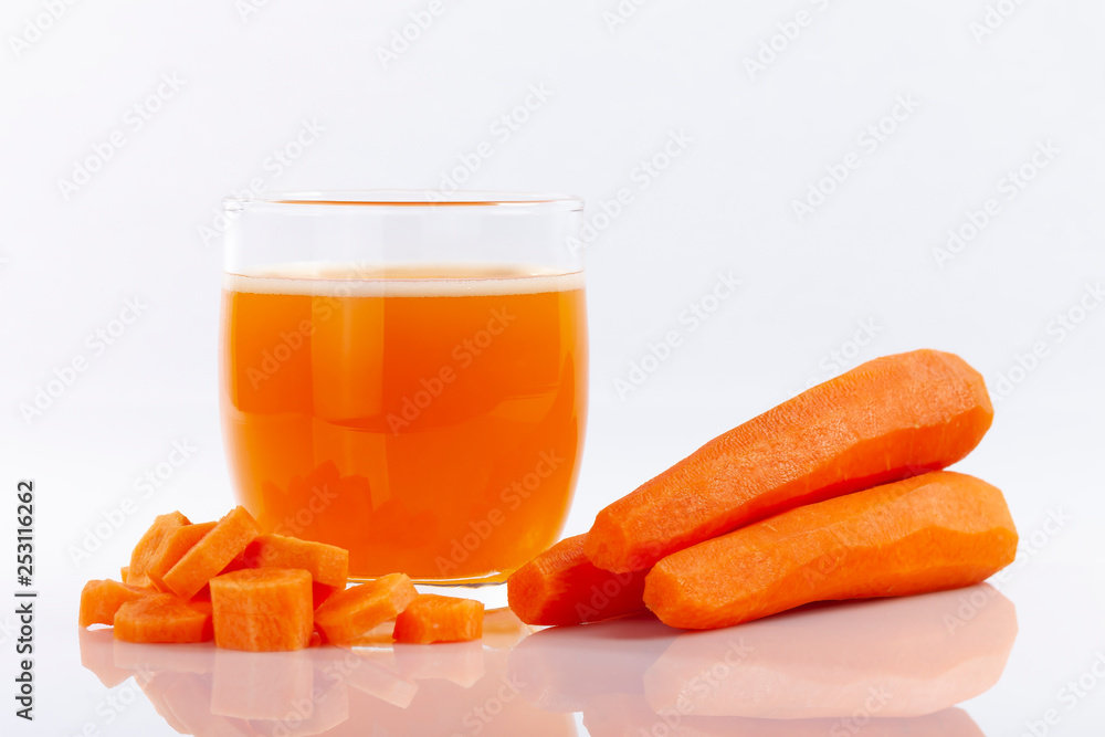 A carrot juice next to peeled and cut carrots isolated A carrot juice next to peeled and cut carrots isolated
