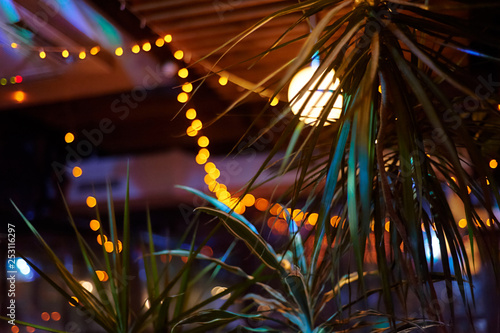 tropical bar athmocphere background with yellow garland bokeh. vacation night life concept