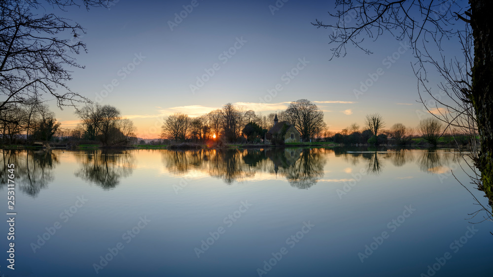 Sunset on Hartley Mauditt pond towards St Leonard's Church, South Downs National Park, Hampshire, UK Sunset on Hartley Mauditt pond towards St Leonard's Church, South Downs National Park, Hampshire, UK