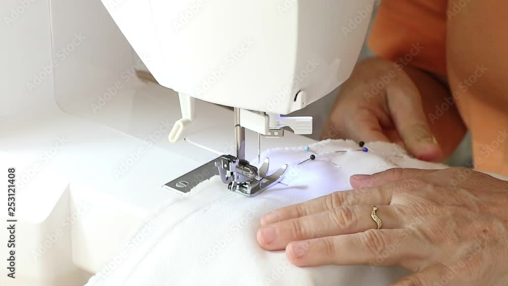 Costurando roupas feitas artesanalmente em seu ateliê