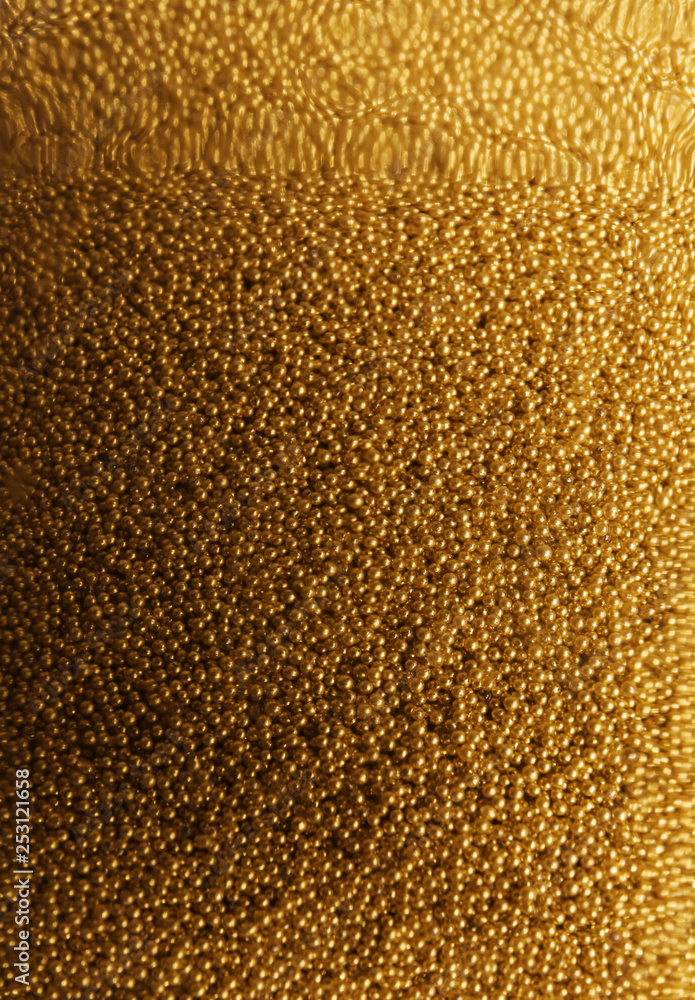 Many gold beads as background, view through glass Many gold beads as background, view through glass