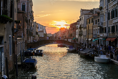 View of Venice at sunset. A ray of sunshine in the frame. A beautiful Italian city with canals and historic architecture. © Sergei Malkov