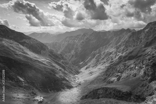Black and white mountain landscape italian alps rays of the sun through the clouds illuminate the valley