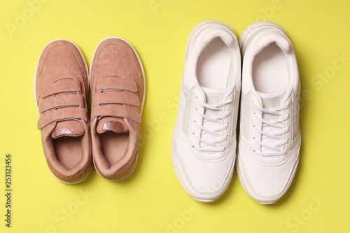  shoes for children and women's sneakers on a colored background top view. Footwear for children and adults.