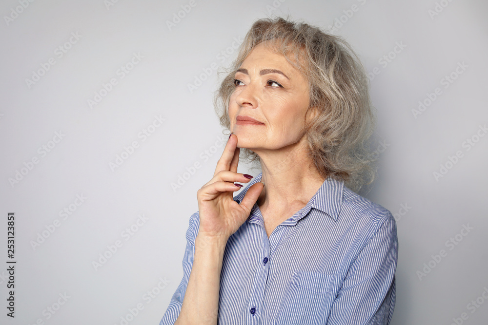 Portrait of mature woman on grey background. Space for text Portrait of mature woman on grey background. Space for text
