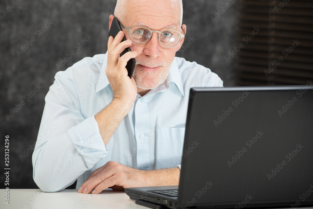 mature businessman with beard talking with phone in the office mature businessman with beard talking with phone in the office