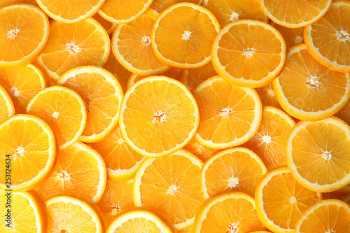 Many sliced fresh ripe oranges as background, top view