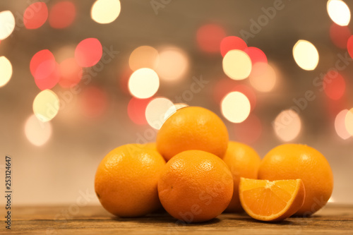 Fresh oranges on wooden table against blurred background. Space for text