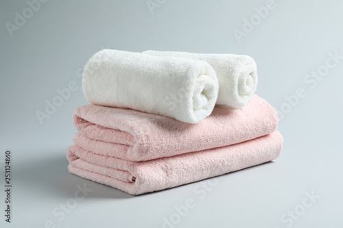 Stack of fresh towels on light background