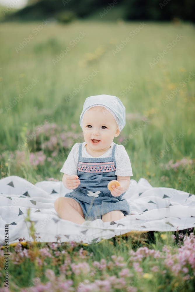 A smiling child is enjoying the nature sitting on the grass A smiling child is enjoying the nature sitting on the grass