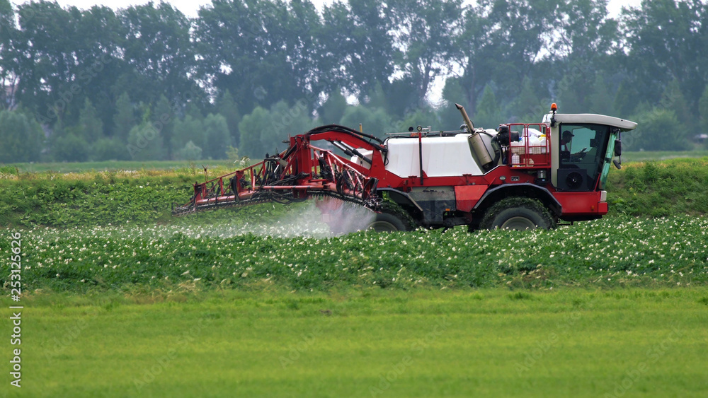 Fototapeta premium Agricultural Tractor sprayer ride in a field