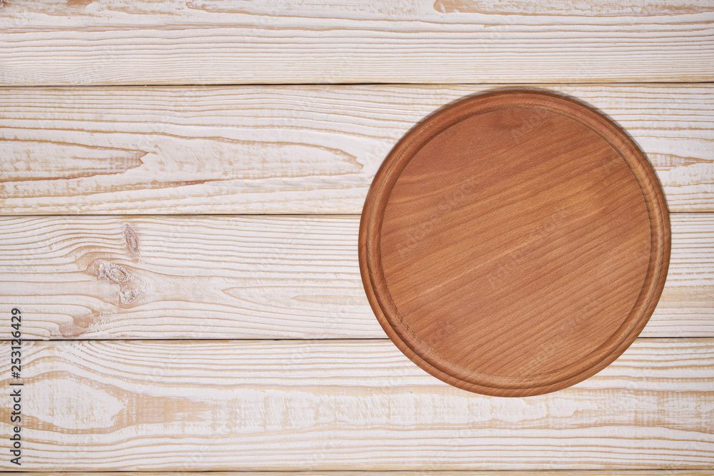 Pizza board on a wooden background, top view. Pizza board on a wooden background, top view.
