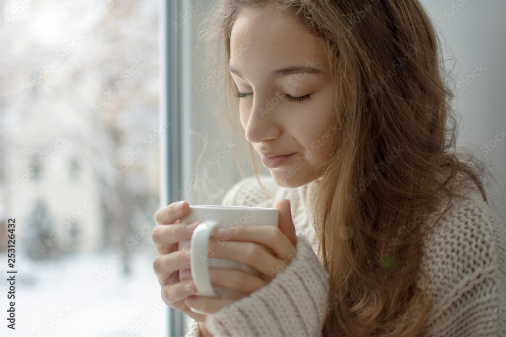 Woman drinking hot drink at home with eyes closed Woman drinking hot drink at home with eyes closed