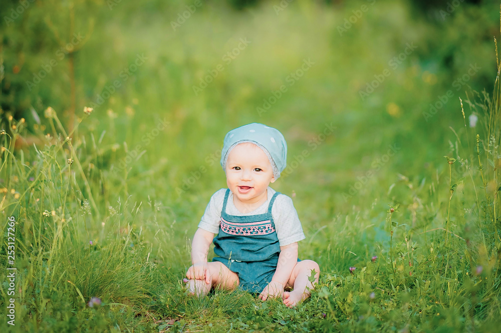 A smiling child is enjoying the nature sitting on the grass A smiling child is enjoying the nature sitting on the grass