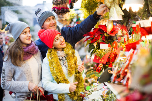 family of three with teenage girl choosing floral decorations at market. Shallow depth of focus