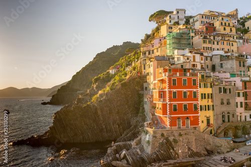 Golden sunset at the cliff at the Italian Riviera in the Village of Riomaggiore, Cinque Terre, Italy