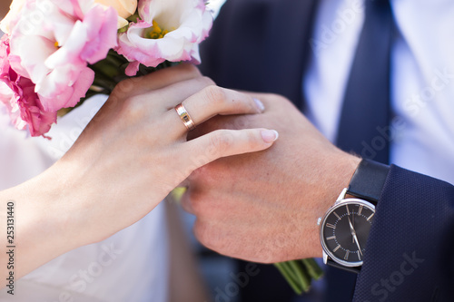 Young couple man and a woman after the wedding in a love photo session in the park on a bench.