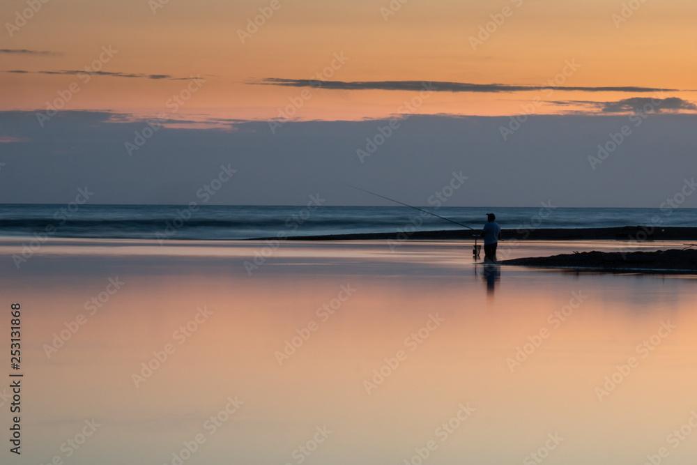 silhouette of a fisherman at the mouth of the Sele river at sunset, Salerno, Campania, Italy