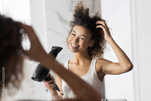 Cute afro girl drying hair photo