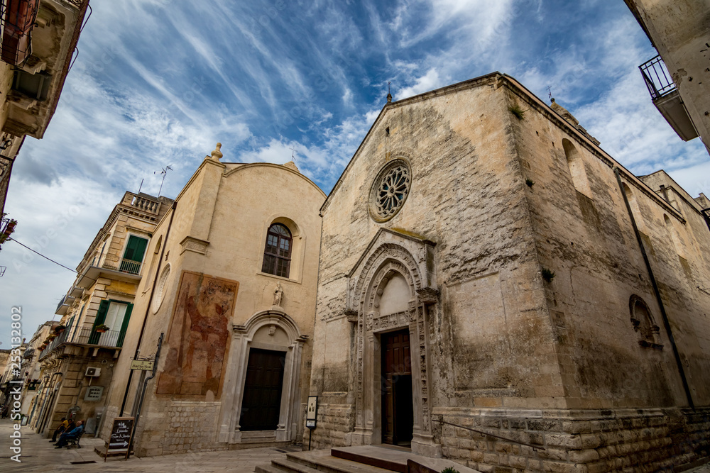 ALTAMURA, ITALY - AUGUST 26, 2018: Amazing church of St. Nicholas of the Greeks or Saint Nicola in Altamura. Apulia. Italy. Dreamy summer afternoon with cloudy sky. View from below, street perspective