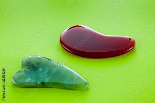 Guasha scrapers for body massage according to the ancient method shot on a bright green background photo