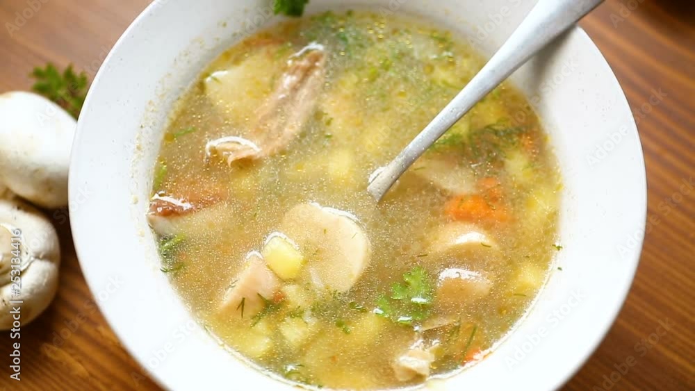 homemade rural soup with vegetables and mushrooms in a bowl on a wooden table homemade rural soup with vegetables and mushrooms in a bowl on a wooden table