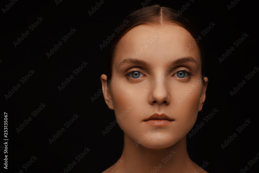 Close-up portrait of a beautiful model with clean makeup and collected hair, photographed in a photo studio Close-up portrait of a beautiful model with clean makeup and collected hair, photographed in a photo studio