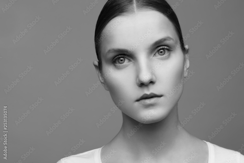 Close-up portrait of a beautiful model with clean makeup and collected hair, photographed in a photo studio Close-up portrait of a beautiful model with clean makeup and collected hair, photographed in a photo studio