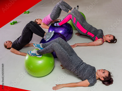 A group of women doing fitness training with balls in the gym