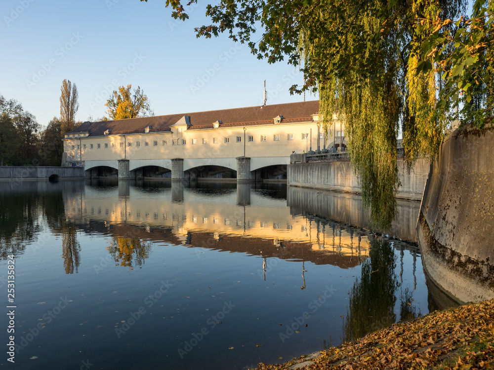 Obraz premium Oberföhringer Wehr in der Abendsonne mit Spiegelung im Wasser, Englischer Garten, München