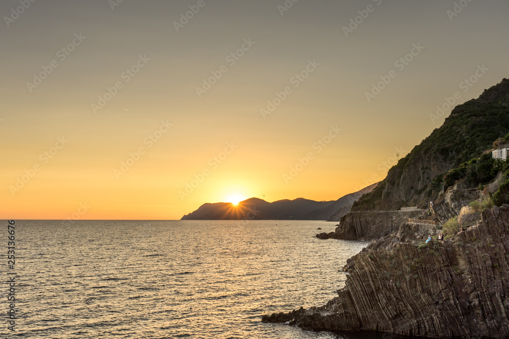 Golden sunset at the cliff at the Italian Riviera in the Village of Riomaggiore, Cinque Terre, Italy