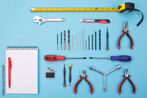 set of metalwork tools with notebook and pen on colorful background photo