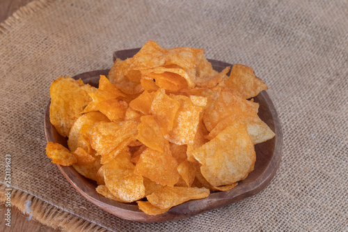 close up of Crispy potato chips on wooden bowl