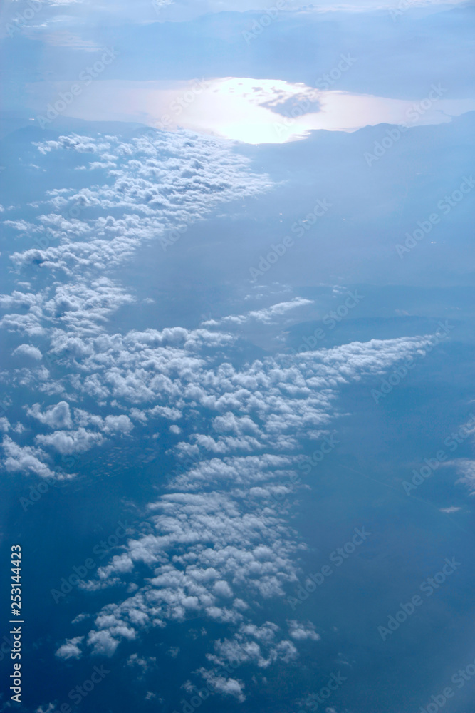 Heavenly landscape with shining sun. White clouds on blue sky