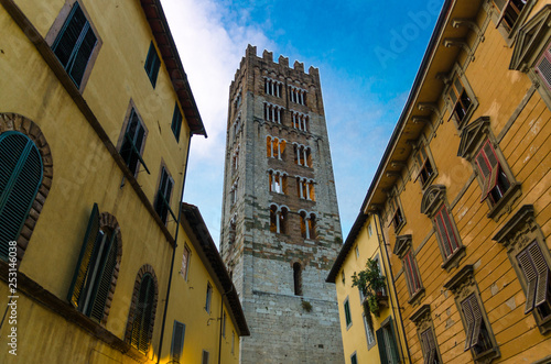 Bell tower of Chiesa di San Frediano catholic church view below from narrow street in historical centre of old medieval town Lucca  evening view  Tuscany  Italy